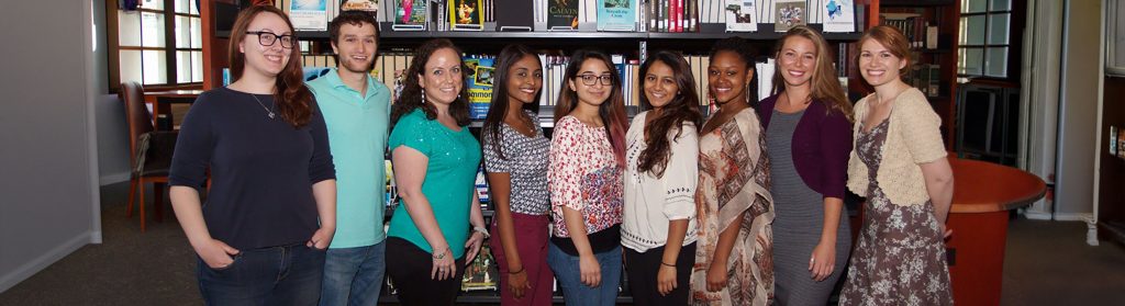 Kimberly with CapLab students posing in front of books