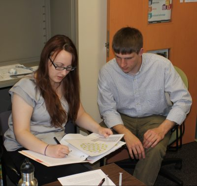 two students working together looking at papers