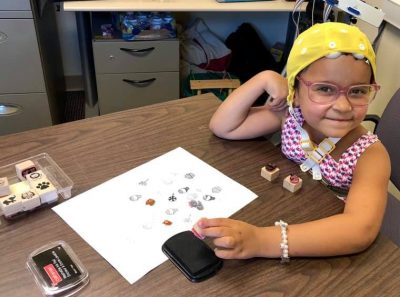 Girl wearing a cap playing one of the research games