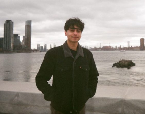 Ali in front of a city skyline.