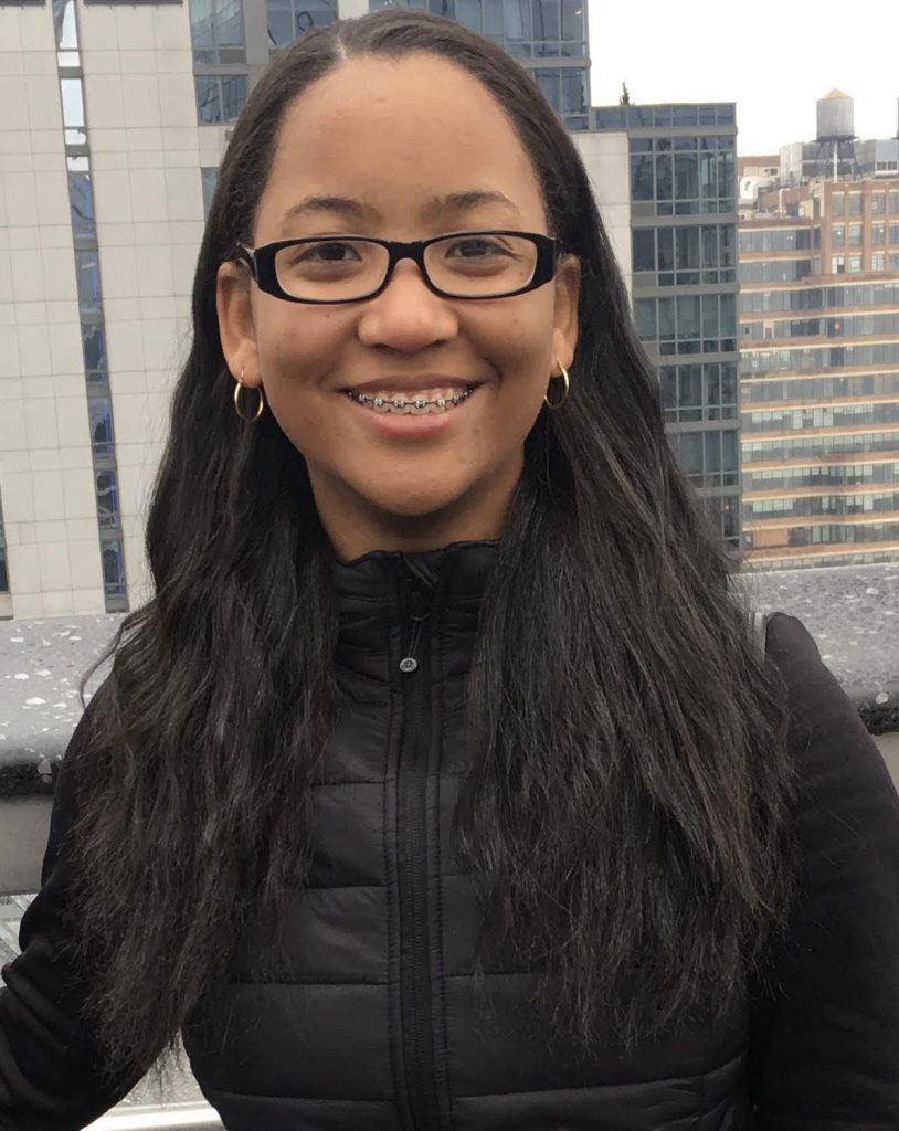Raynia in front of a city skyline.