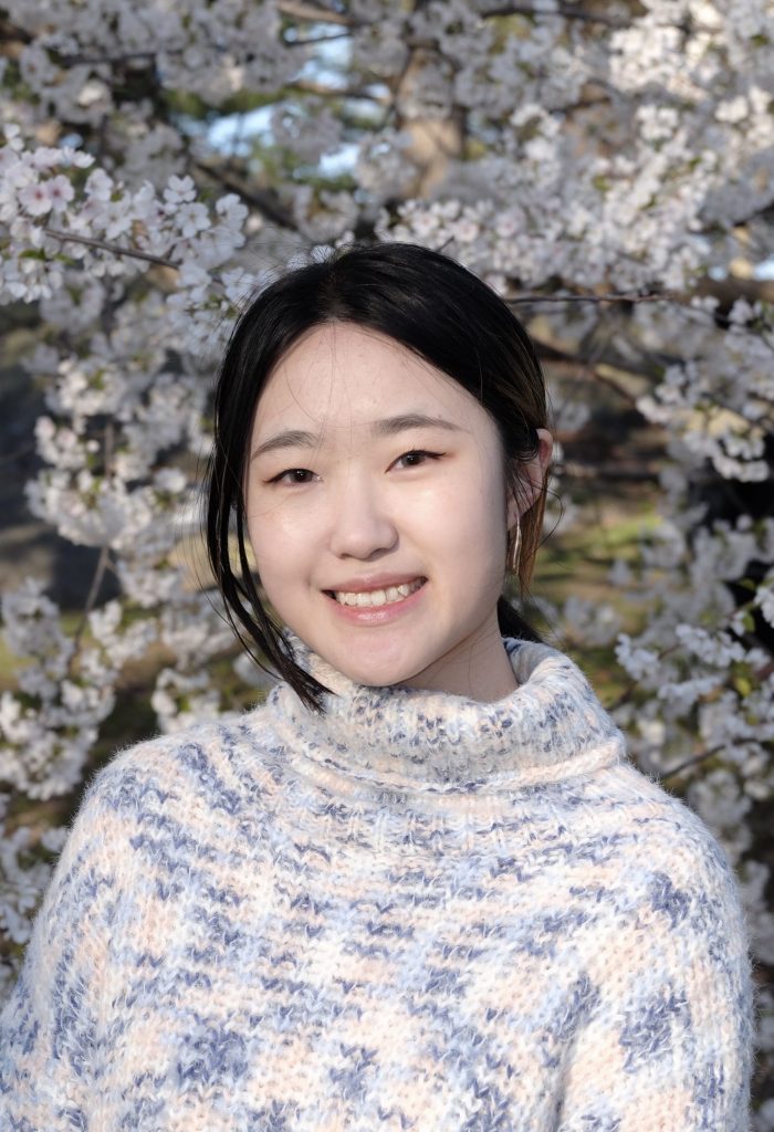 Siqi in front of a flowering tree.