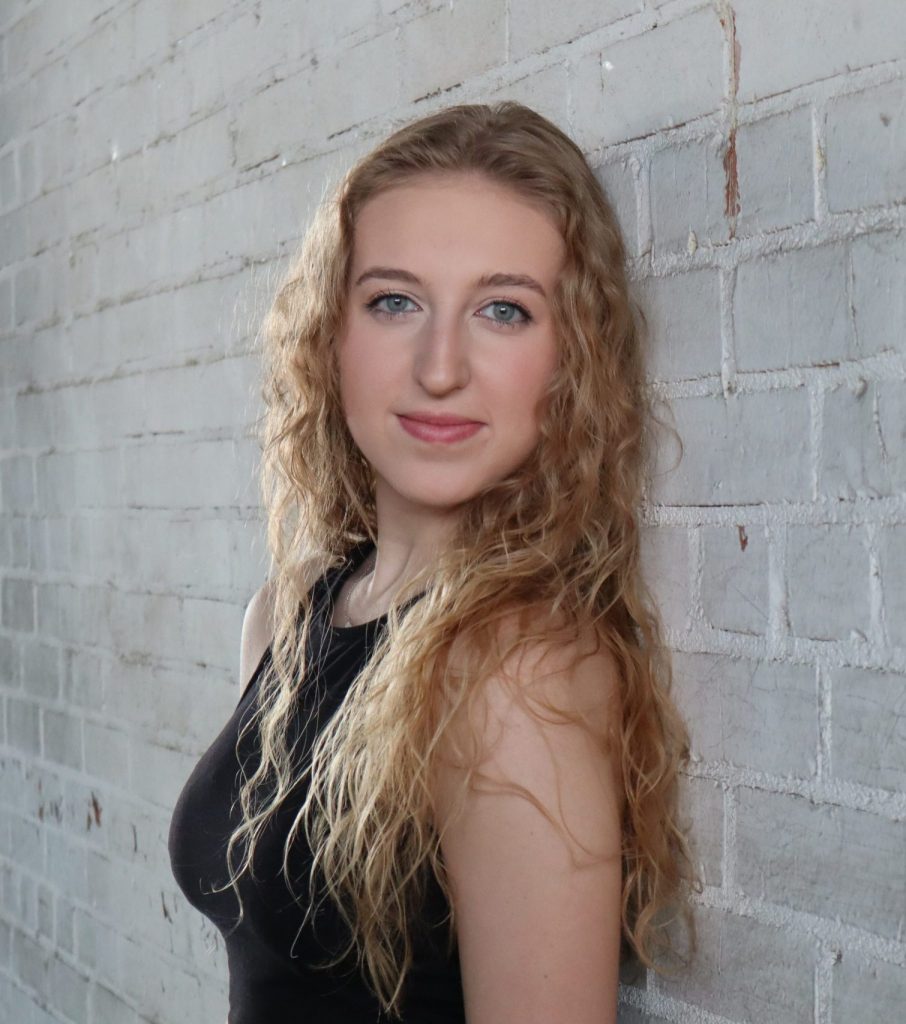 Delaney in front of a stone wall.